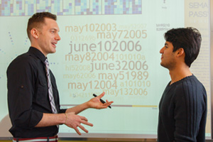 Dr. Christopher Collins (left), UOIT Canada Research Chair in Linguistic Information Visualization, speaks with PhD student Rafael Veras Guimarães (Computer Science) in the Faculty of Science's Visualization for Information Analysis Laboratory (Vialab).